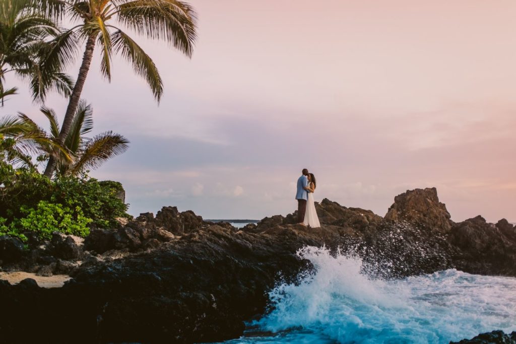 Tim & Angela with palm trees and waves along a beautiful Maui coastline.