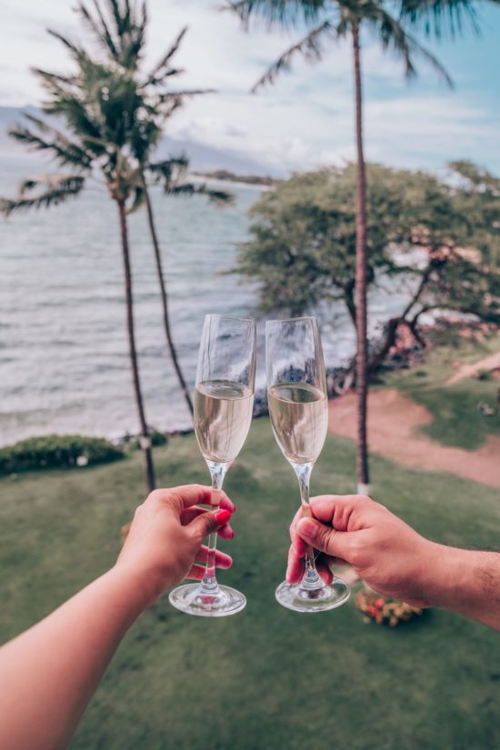 Champagne glasses toasting on the Maui Beachside lanai with the ocean view in Maui, HI