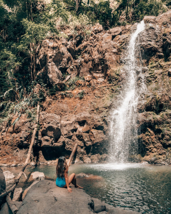 Shem sitting on a rock at Waikani Falls "Three Bears Falls"